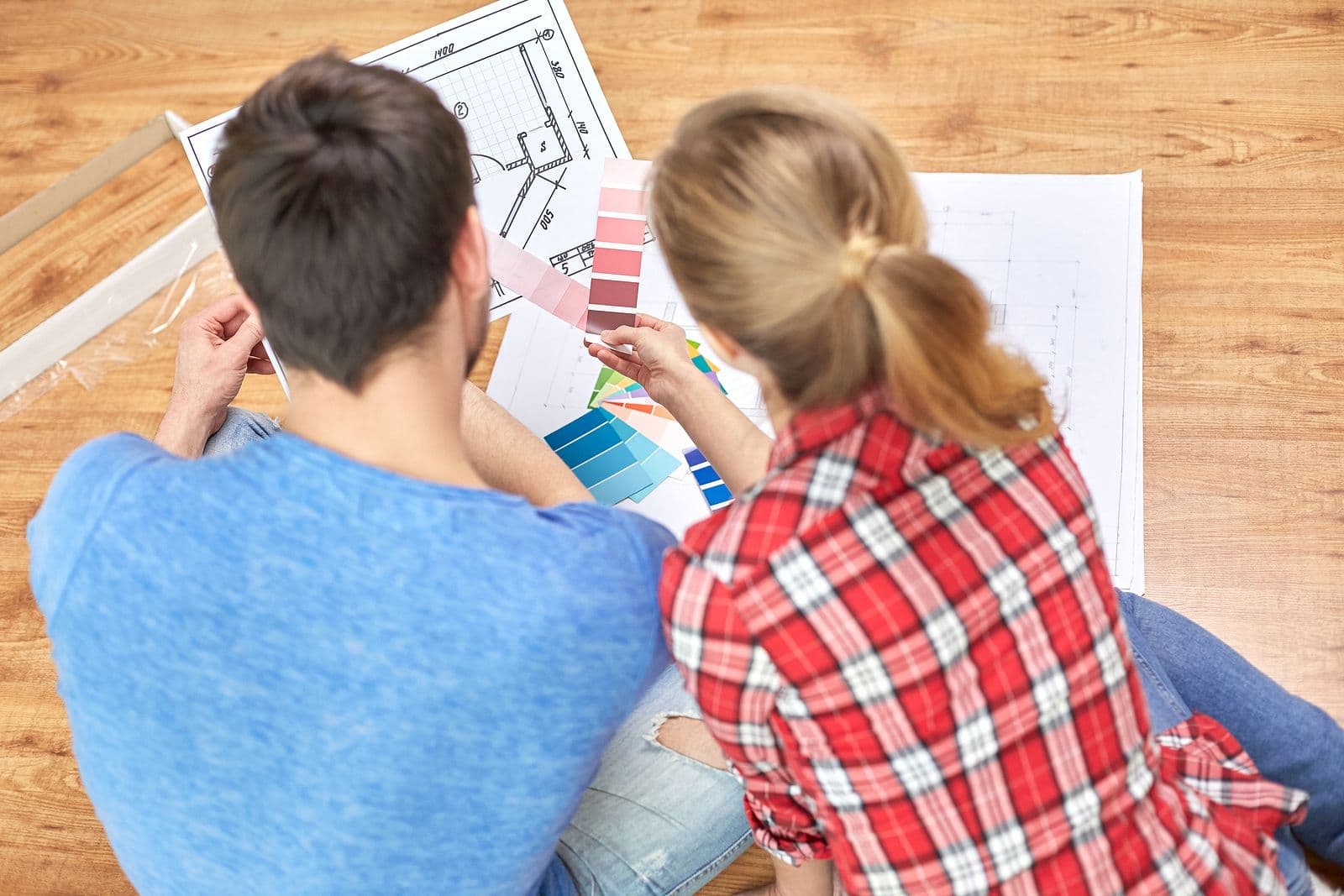 A couple looks over designs and paint swatches.