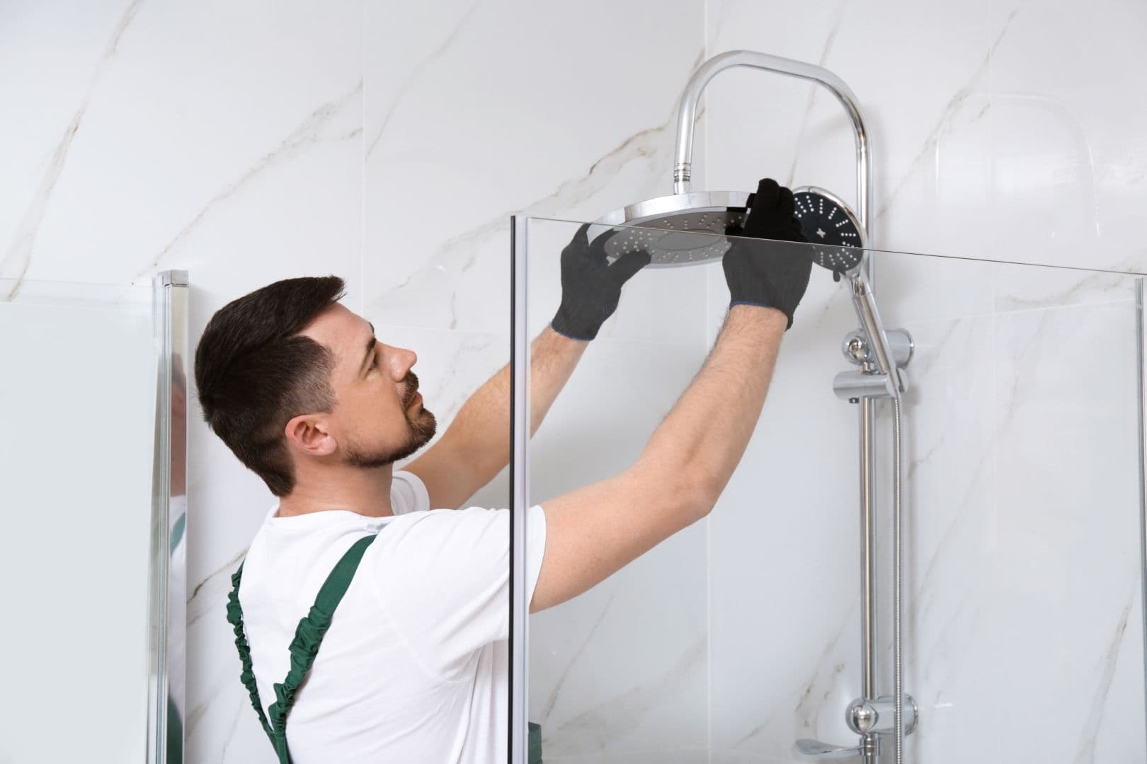 Professional Handyman installing a shower head.